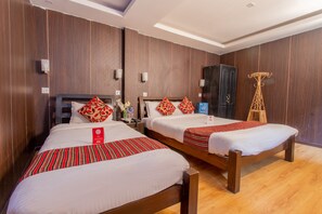 Two single beds with red and white bedding, wooden headboards, and a dark wooden wardrobe. - Traveler's Holiday Inn (Kathmandu)