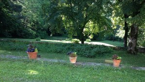 A grassy area with a white metal chair and three potted plants. - Chateau de Laric (Chabestan)