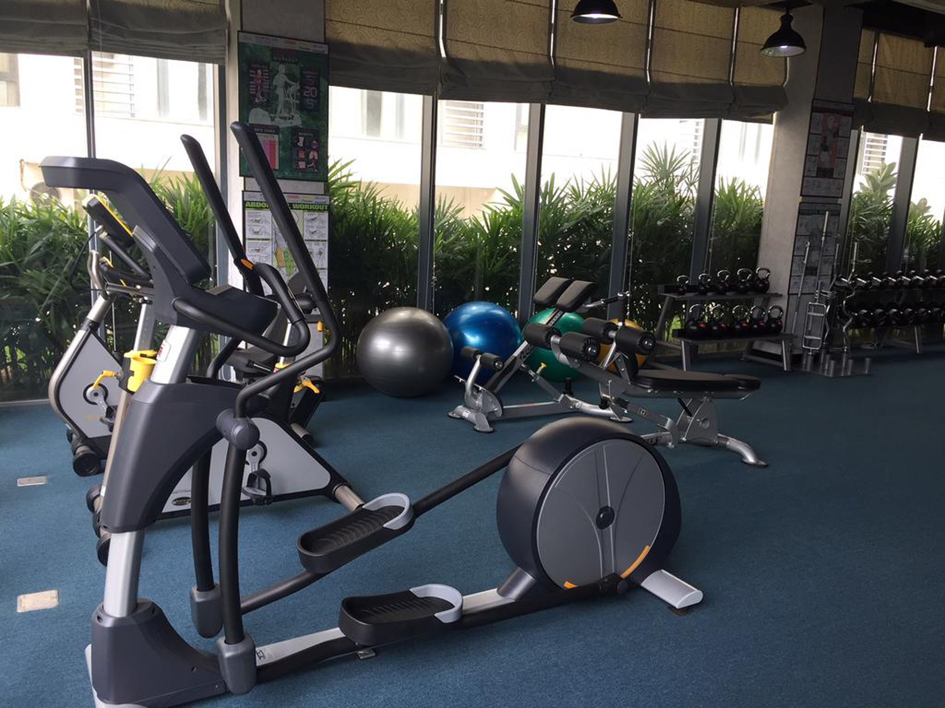 A gym with exercise equipment, including treadmills, an elliptical, and free weights.