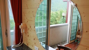 A wooden cabin room with a large window, a telephone, and a small table. - King Taiwan (Lugu)