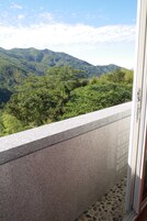 Un balcón con vistas a una cordillera boscosa.