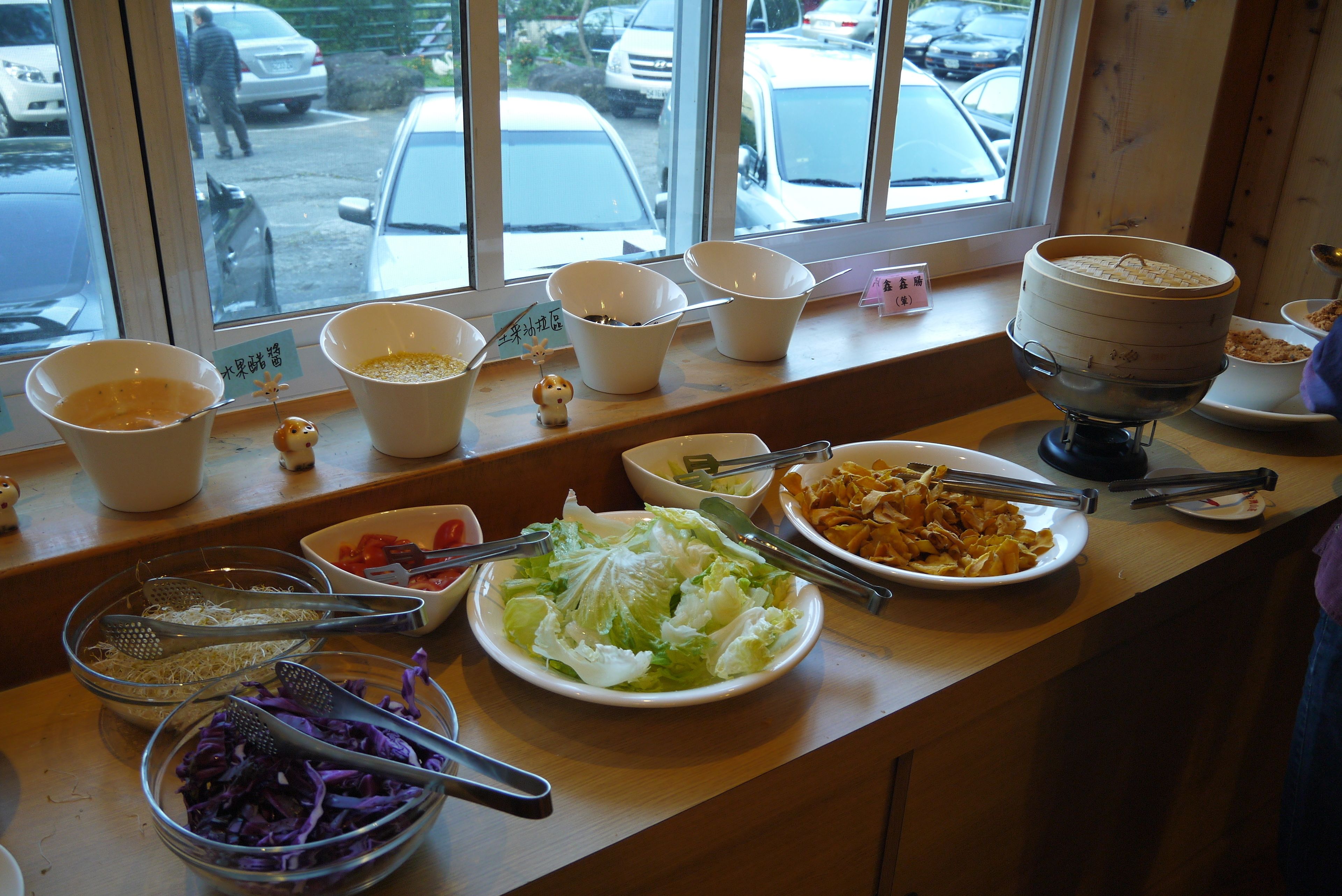 A buffet table with various dishes and utensils.