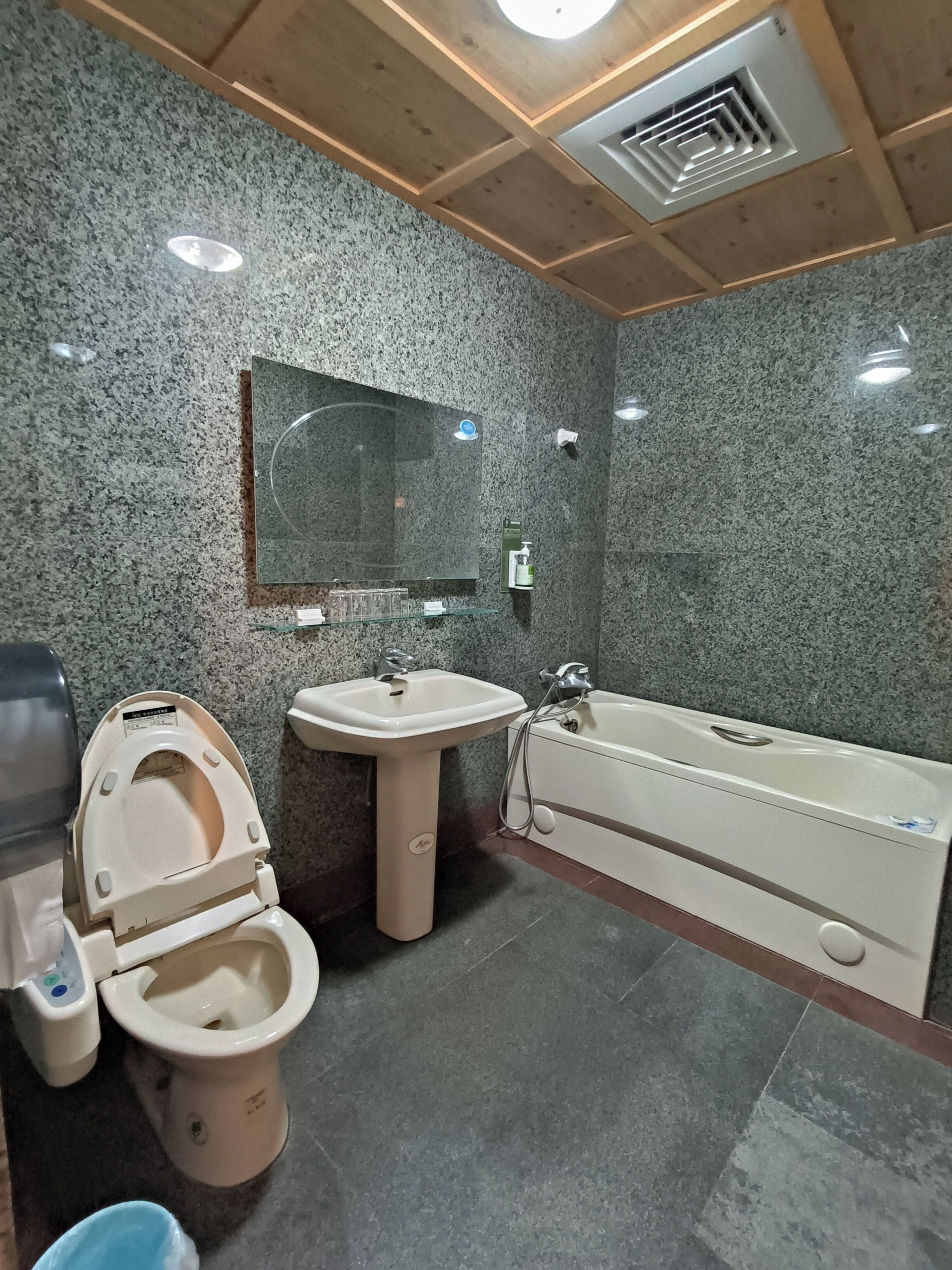 Une salle de bain avec des toilettes, un lavabo et une baignoire.