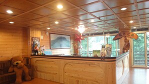 A reception area with a wooden counter, a large framed picture on the wall, and a star decoration. - King Taiwan (Lugu)