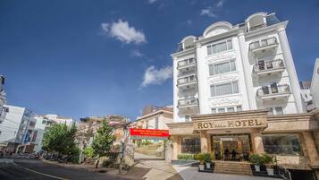 A hotel with a classic facade, multiple balconies, and a prominent entrance.
