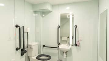 Een moderne badkamer met toilet, wastafel en spiegel.