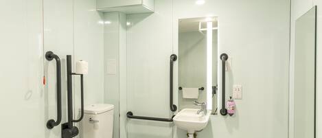 Un baño moderno con inodoro, lavamanos y espejo.