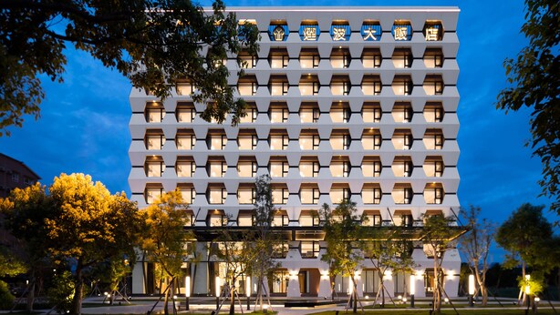 A modern hotel with a unique geometric facade, multiple balconies, and a well-lit entrance area. - Lakeshore Hotel Yilan (Yilan)