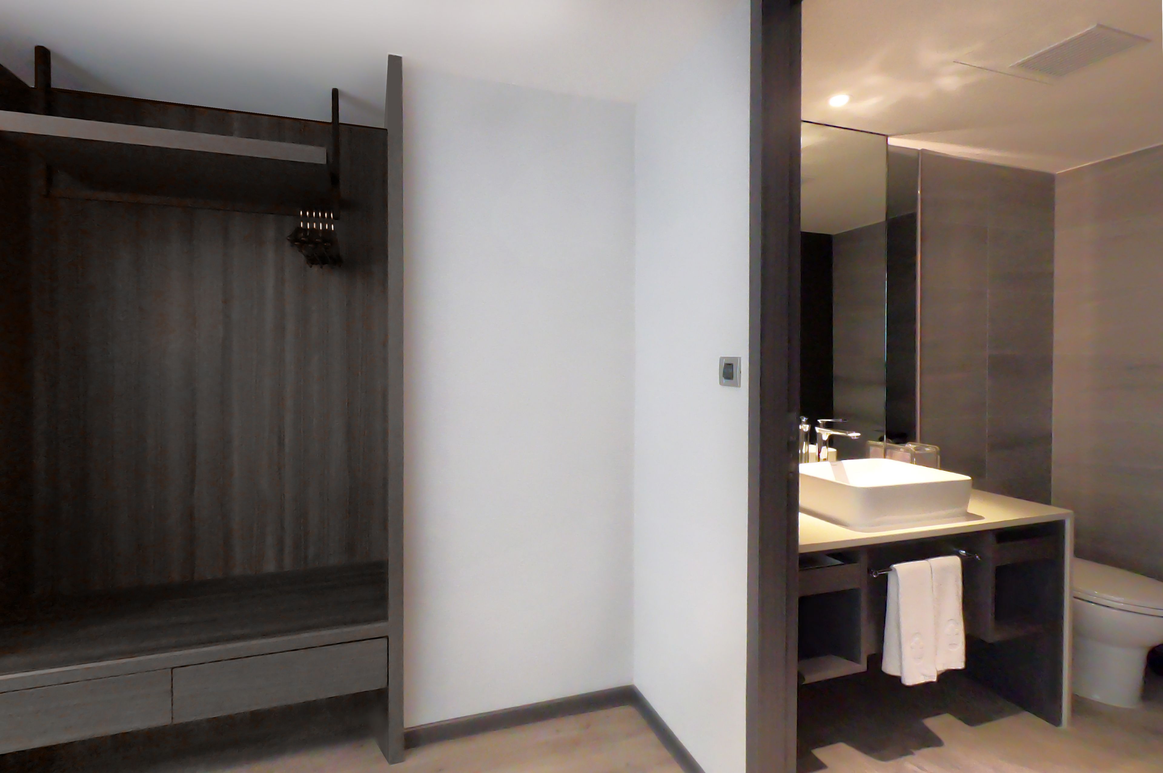 A modern bathroom with a large mirror, a white sink, and a shower area.