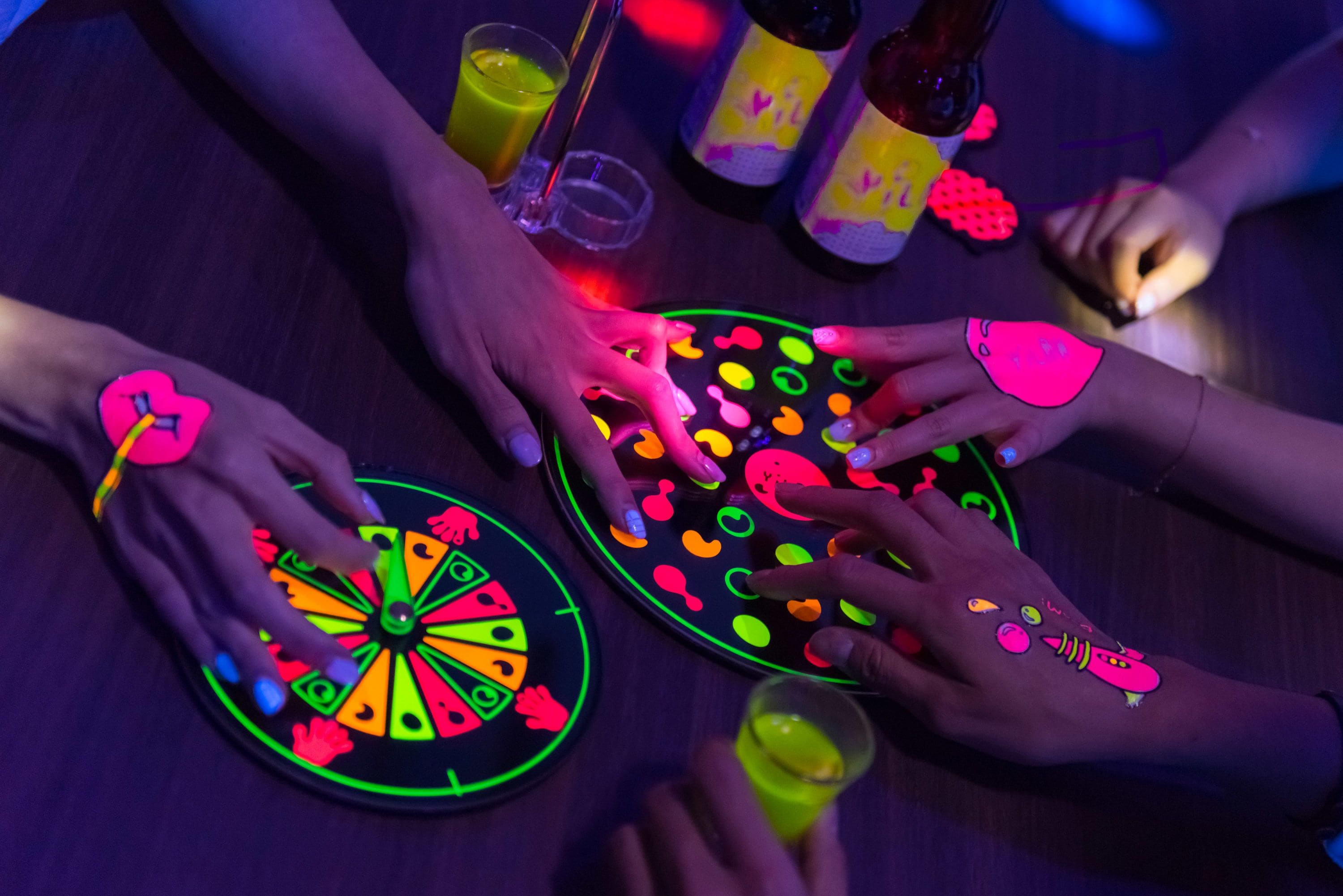 A group of people playing a glowing game with colorful hand-painted designs.