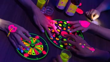 A group of people playing a glowing game with colorful hand-painted designs.