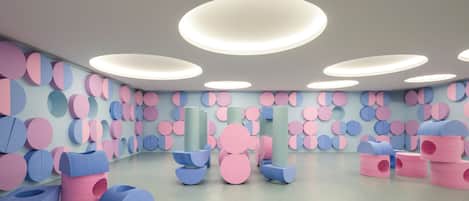 Un interior moderno con luces circulares en el techo, una pared con diseño y muebles geométricos.