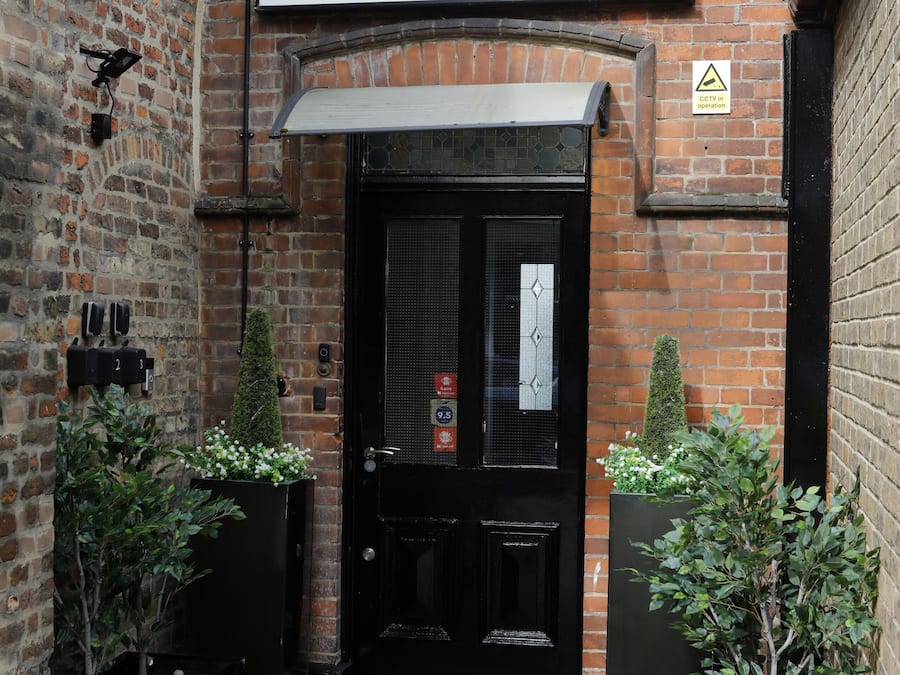 Edifício de tijolos com uma placa que diz "Village Hotel Entrance".