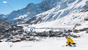 Une ville de montagne enneigée où l’hôtel Marmore est clairement visible.