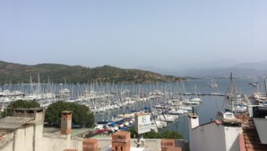 Un port de plaisance où sont amarrés de nombreux bateaux, une enseigne indiquant « ECE SARAY MARINA & RESORT », et un paysage vallonné en arrière-plan.