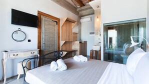 Ein Schlafzimmer mit Bett, Schreibtisch, Stuhl, Spiegel und Fernseher.