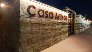 Eine Steinsäule mit der beleuchteten Aufschrift "Casa Afytos Suites" in der Nacht.