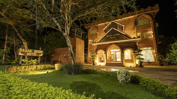 Vista frontal de la propiedad por la tarde o noche