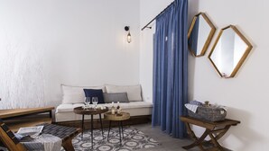 A cozy living room with a sofa, a coffee table, a side table, and a patterned rug. - Blue Jasmine Suites (Rhodes)