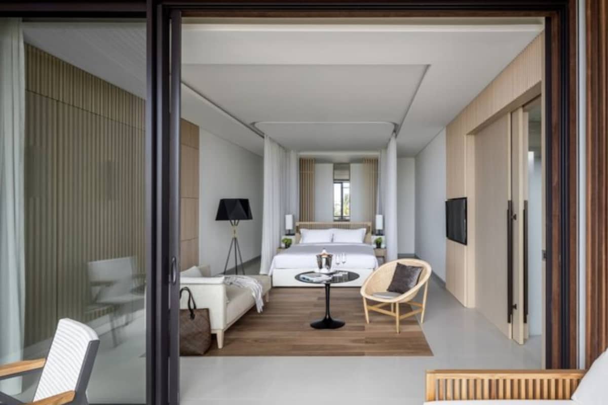 Une chambre d’hôtel moderne équipée d’un lit, d’une petite table, d’une chaise et d’un téléviseur.