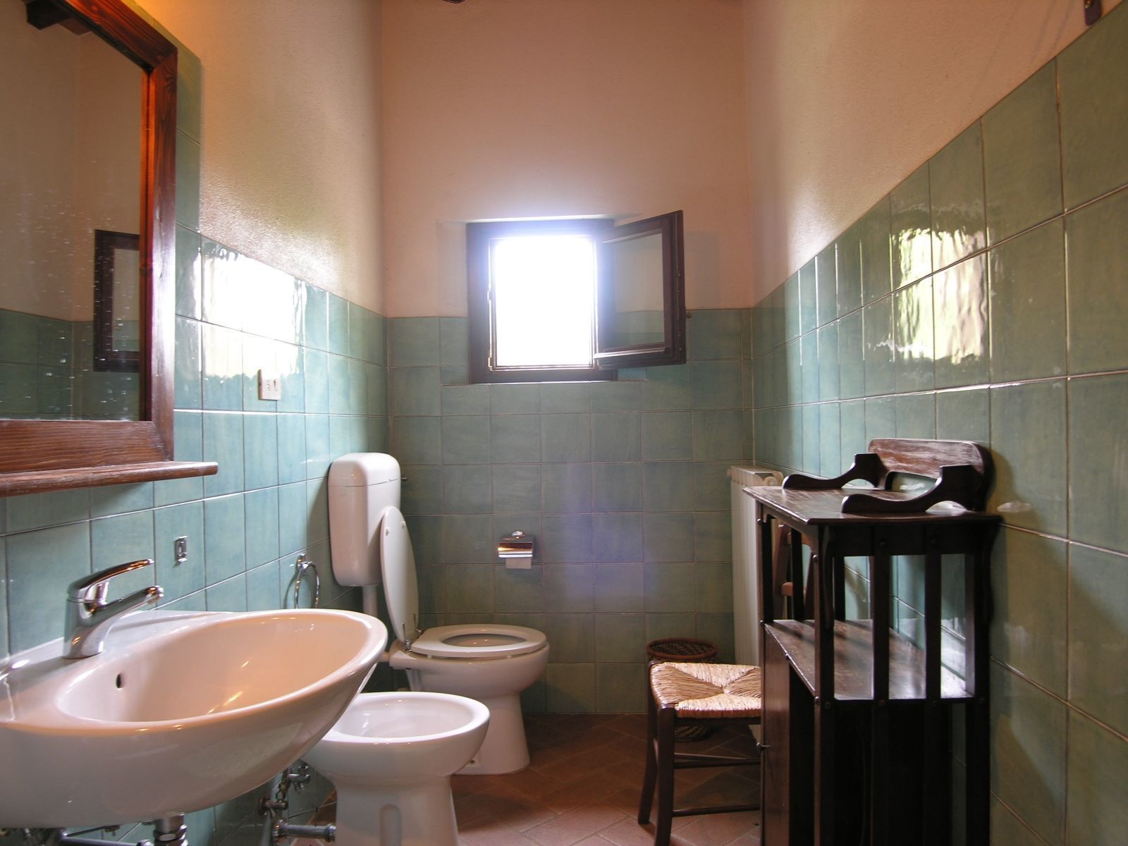 Une salle de bain avec un lavabo, des toilettes et un miroir.