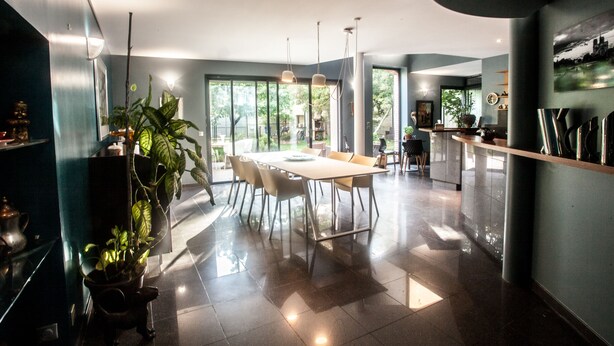 A modern kitchen with a large island, ample natural light, and a view of the outdoors. - La Closerie aux Violettes chambres d'hôtes (Toulouse)