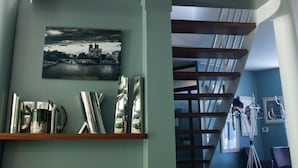 A modern interior with a spiral staircase, a wooden ceiling, and a framed picture on the wall. - La Closerie aux Violettes chambres d'hôtes (Toulouse)
