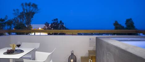 An outdoor dining area with a table set for two, a chair, and a lantern.