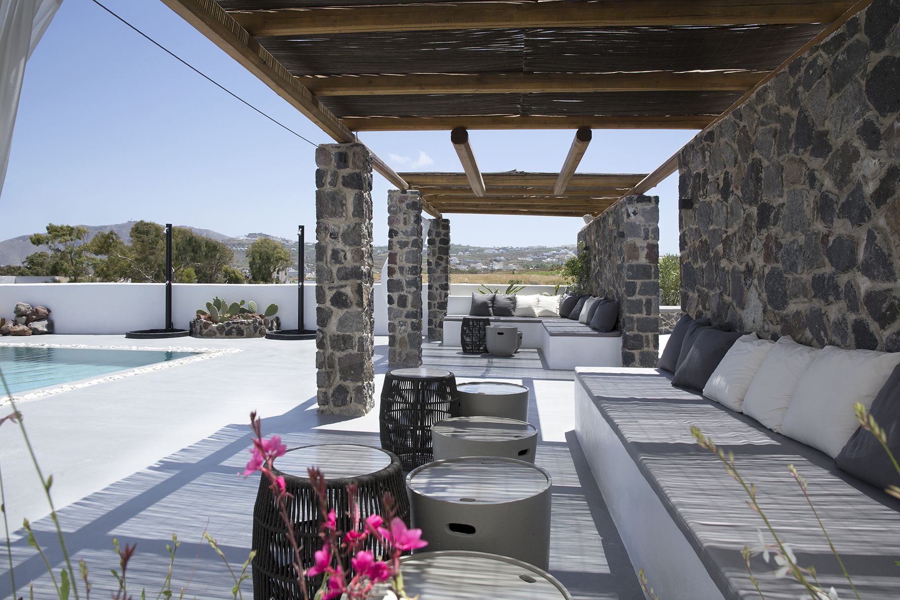 Un espace extérieur aménagé avec des piliers en pierre, une piscine et une vue sur le paysage.