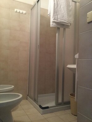 Ein Badezimmer mit Duschkabine, Toilette und Waschbecken.