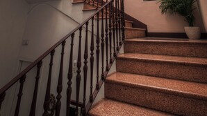 A staircase with wooden balusters and carpeted steps leading to an upper floor. - Palazzo Vaglio Relais (Nardò)