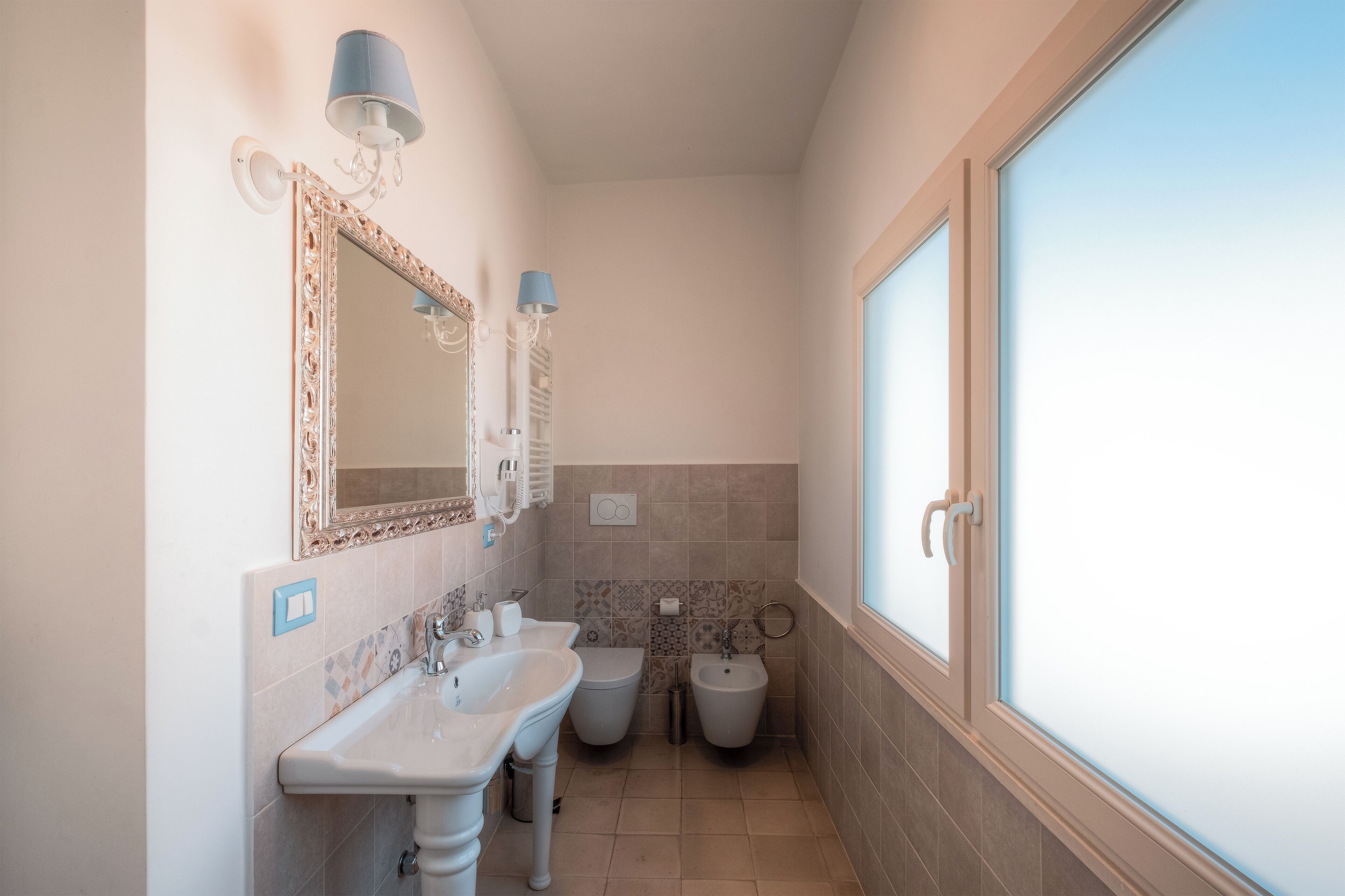 Uma casa de banho com duas pias, uma sanita e um bidé.