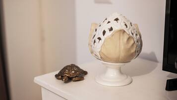 A white pedestal with a decorative object resembling a turtle and a spherical object with intricate patterns.