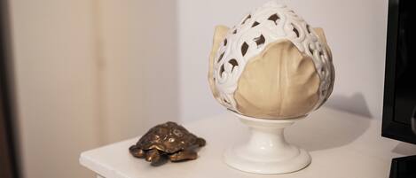 A white pedestal with a decorative object resembling a turtle and a spherical object with intricate patterns.