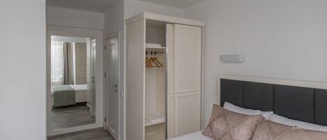 Una habitación de hotel con cama, armario y espejo.