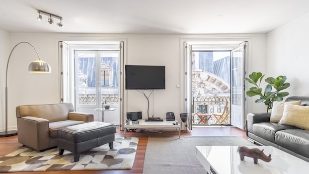 Una sala de estar moderna con un sofá, una mesa de centro y un televisor.