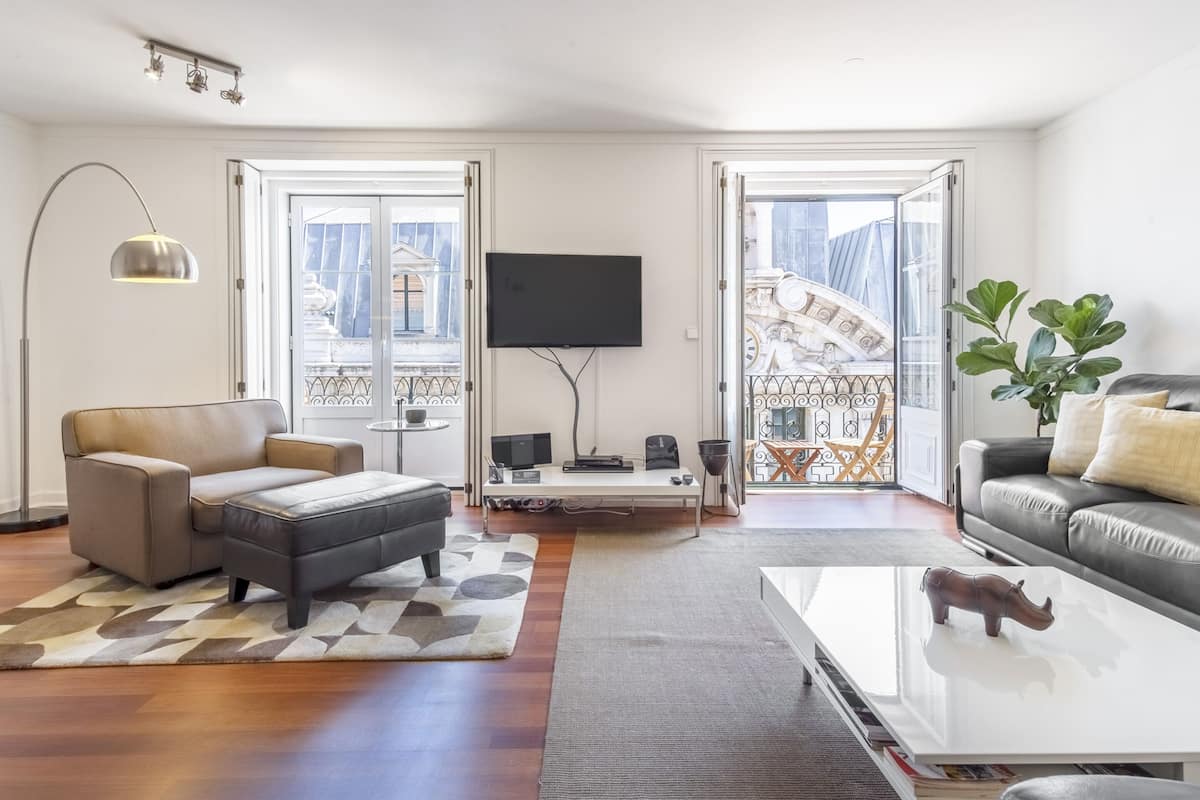 A modern living room with a sofa, a coffee table, and a TV.