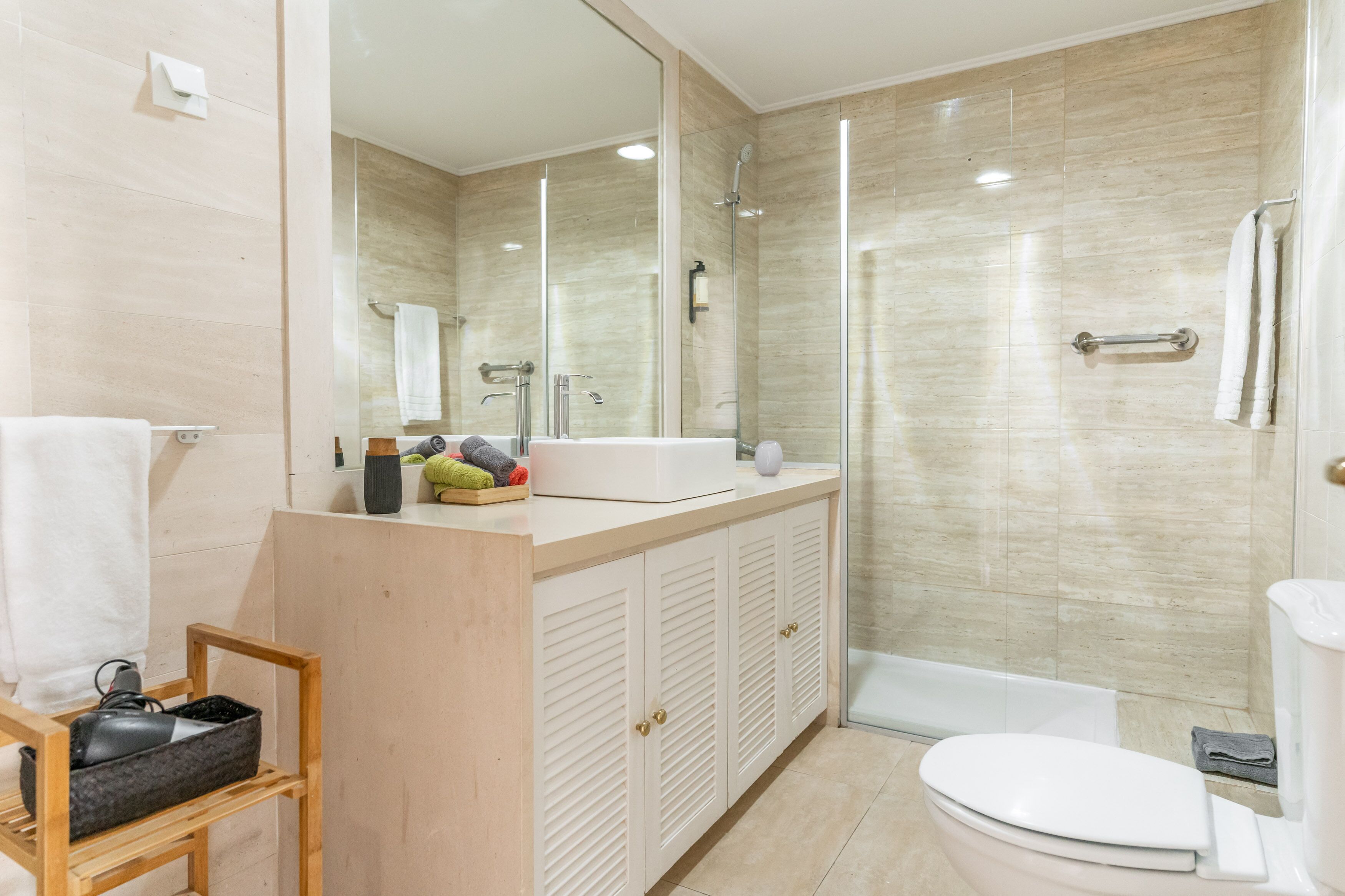 A modern bathroom with a shower, toilet, and vanity.