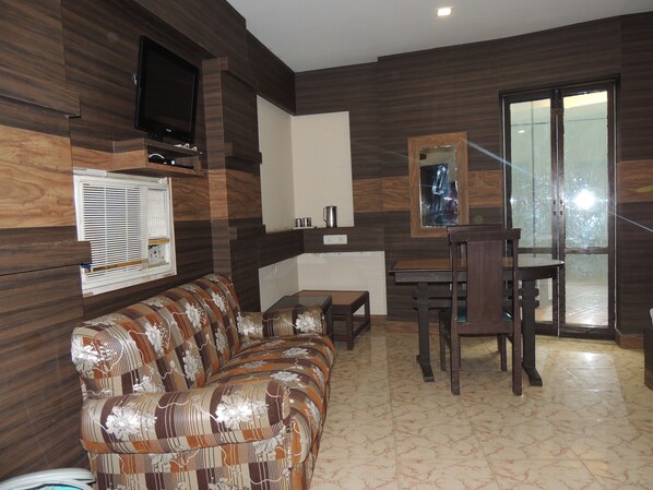 Habitación doble estándar, 1 cama King size | Área de sala de estar | Televisión de pantalla plana