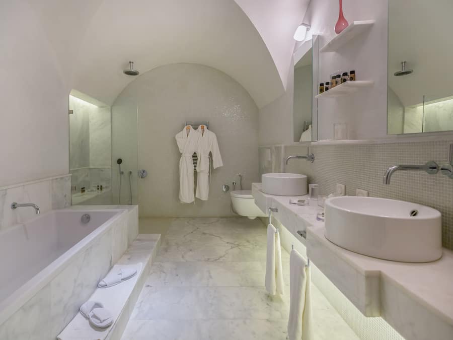 A modern bathroom with a freestanding bathtub, a double sink vanity, and a large mirror above the vanity.