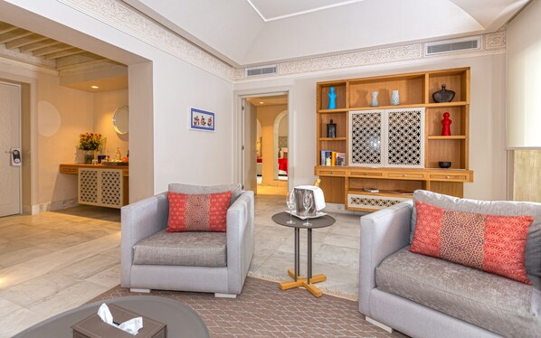 A modern living room with two grey sofas, a small round table, and a decorative cabinet with patterned doors. - Dar el Jeld Hôtel & Spa (Tunis)