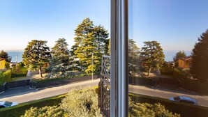A residential street with houses, trees, and a clear sky. - Dimora Gu - lake view terrace, 100m from the beach (Bardolino)