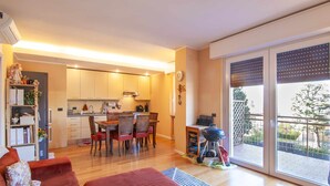A compact living space with a dining area, kitchen, and a balcony with a view. - Dimora Gu - lake view terrace, 100m from the beach (Bardolino)