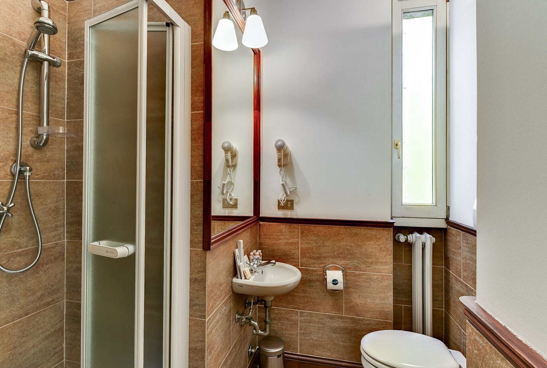 Un bagno con doccia, lavandino e WC.