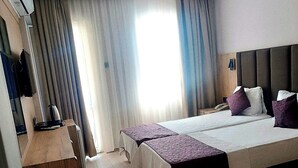 A hotel room with a bed, bedside tables, a desk, and a chair. - Meryemana Hotel (Didim)