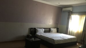 Ein Schlafzimmer mit Bett, Nachttischen und einer Klimaanlage.