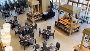 A spacious hotel lobby with multiple dining areas, large windows offering views, and modern furnishings. - Timberland Heights (San Mateo)