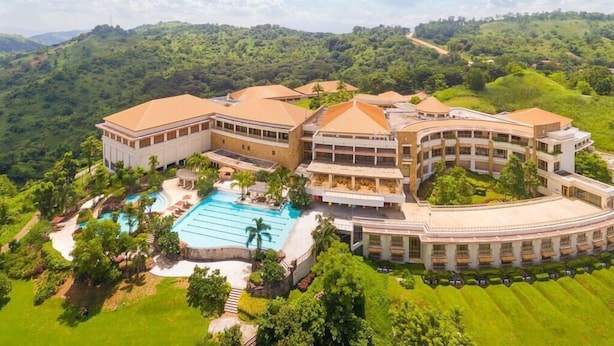 A resort with multiple buildings, a swimming pool, and lush greenery. - Timberland Heights (San Mateo)