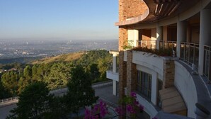 A modern building with a curved roof and a balcony overlooking a cityscape. - Timberland Heights (San Mateo)