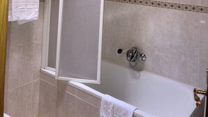A bathroom with a bathtub, a shower enclosure, and tiled walls. - Hotel Silos 2000 (Santo Domingo de Silos)